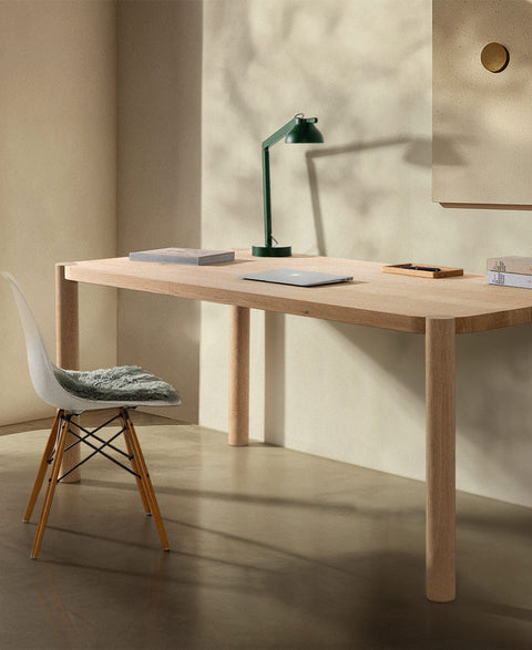 loop schreibtisch aus eiche massivholz eames plastic side chair in weiß mit holzgestell und tischleuchte in sonnendurchflutetem zimmer