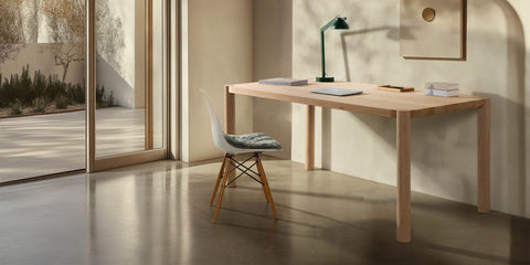 loop schreibtisch aus eiche massivholz eames plastic side chair in weiß mit holzgestell und tischleuchte in sonnendurchflutetem zimmer