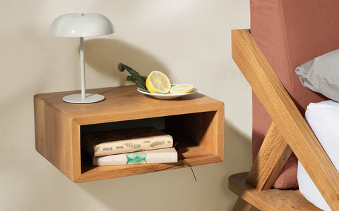 nordic space bett mit rückenpolster in sandstein rot und wandhängender nachtisch aus eiche massivholz mit offenem ablagefach für bücher und tischleuchte darauf