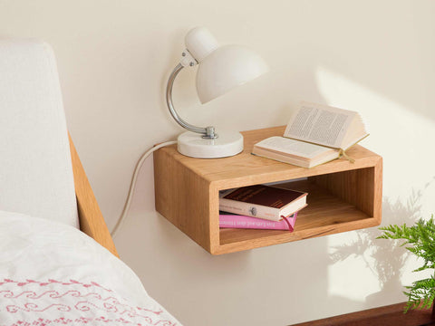 nordic space nachttisch aus eiche massivholz an wand montiert mit dell tischleuchte und büchern darauf