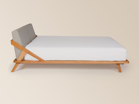 seitenansicht nordic space bett aus massivem eichenholz von ellenberger design mit grauem rückenpolster ab 160cm größe #160-W-180W-200-W